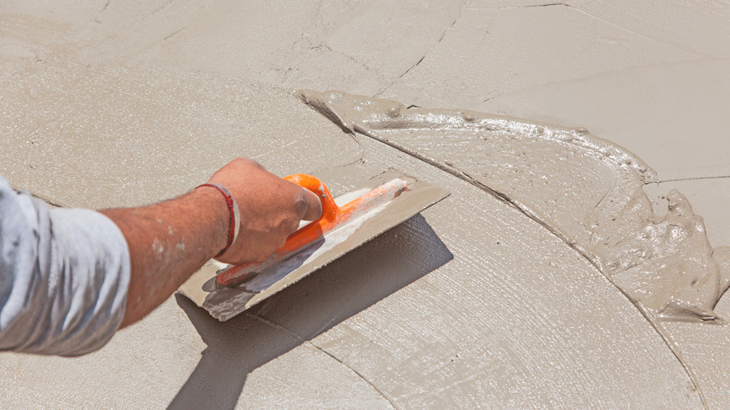 Technicien appliquant un revêtement de plancher au rouleau dans un garage commercial